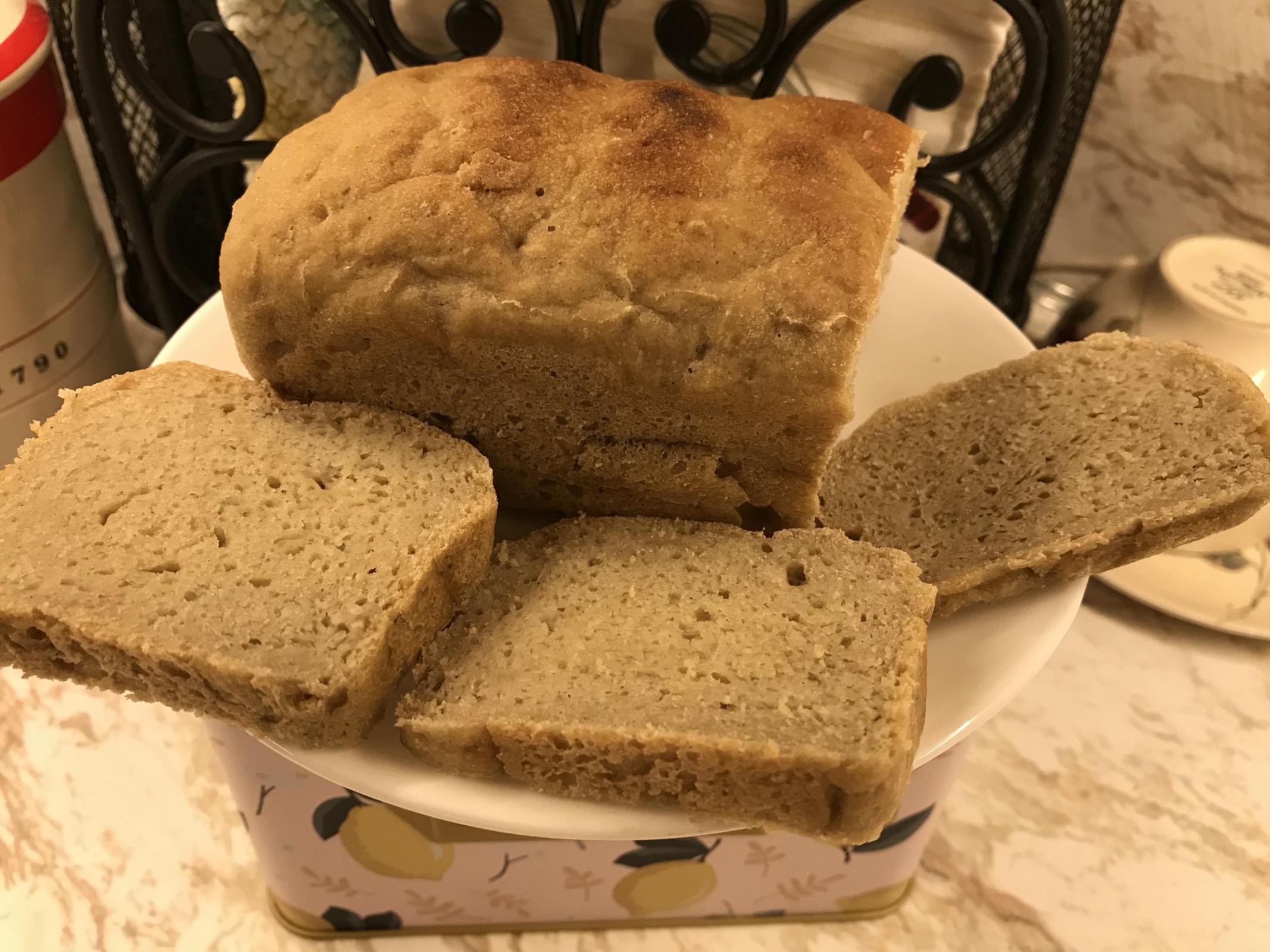 Bread loaf with three slices on plate.