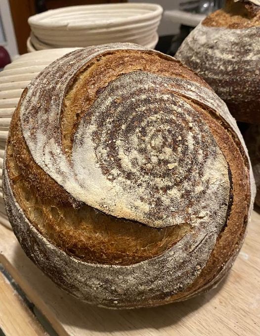 Sourdough loave leaning against bannetons.