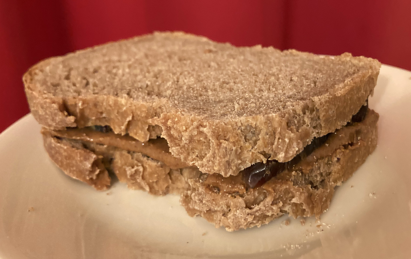 Peanut butter and date sandwich with whole wheat bread on a plate.