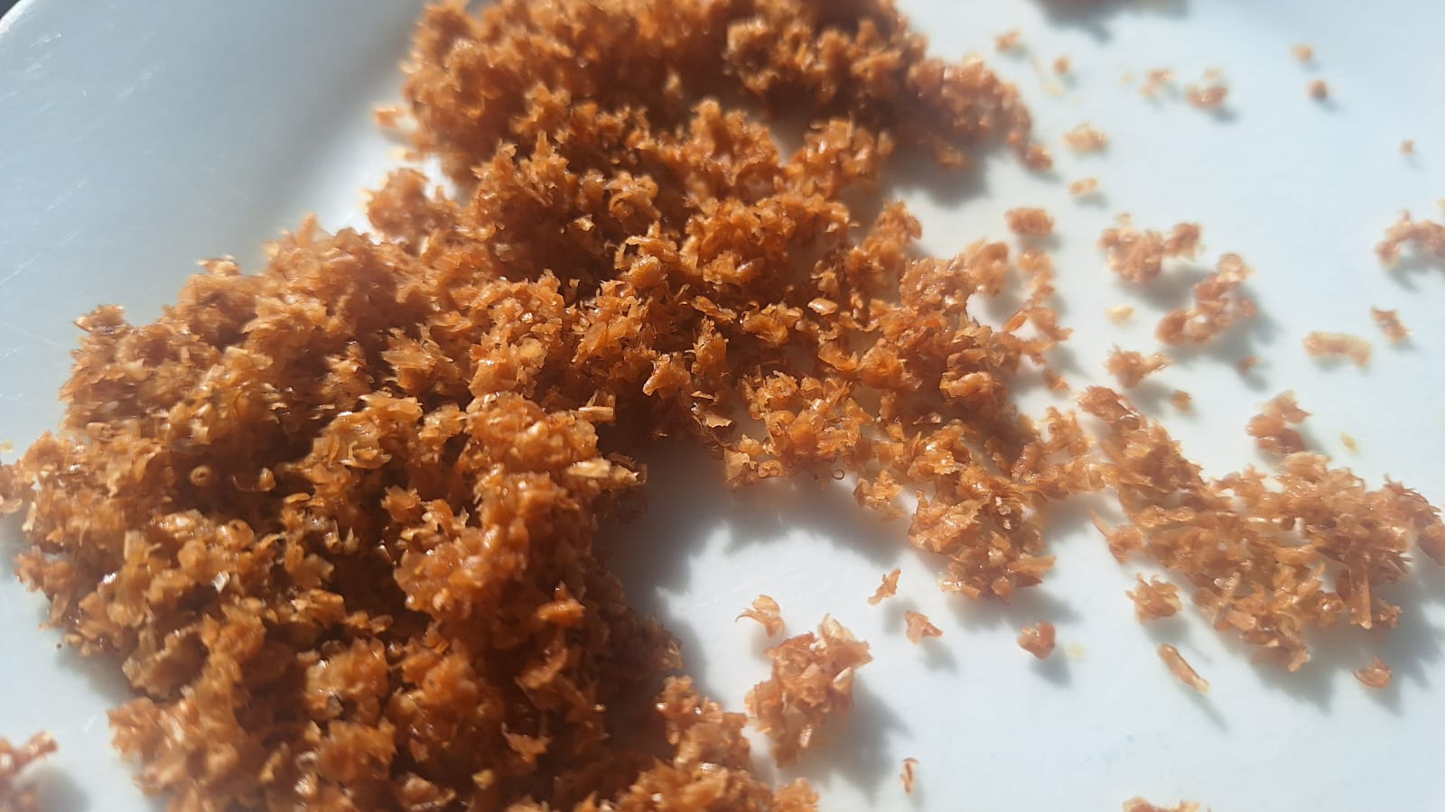 Bran starter on a plate. It looks like moistened bran starter in clumps on a plate.