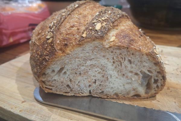 Sliced bread on bread board showing crumb. The breads shows swirls of white and wholewheat dough in cross section.