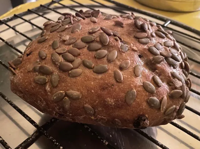 a bread with pumpkin seeds on the crust